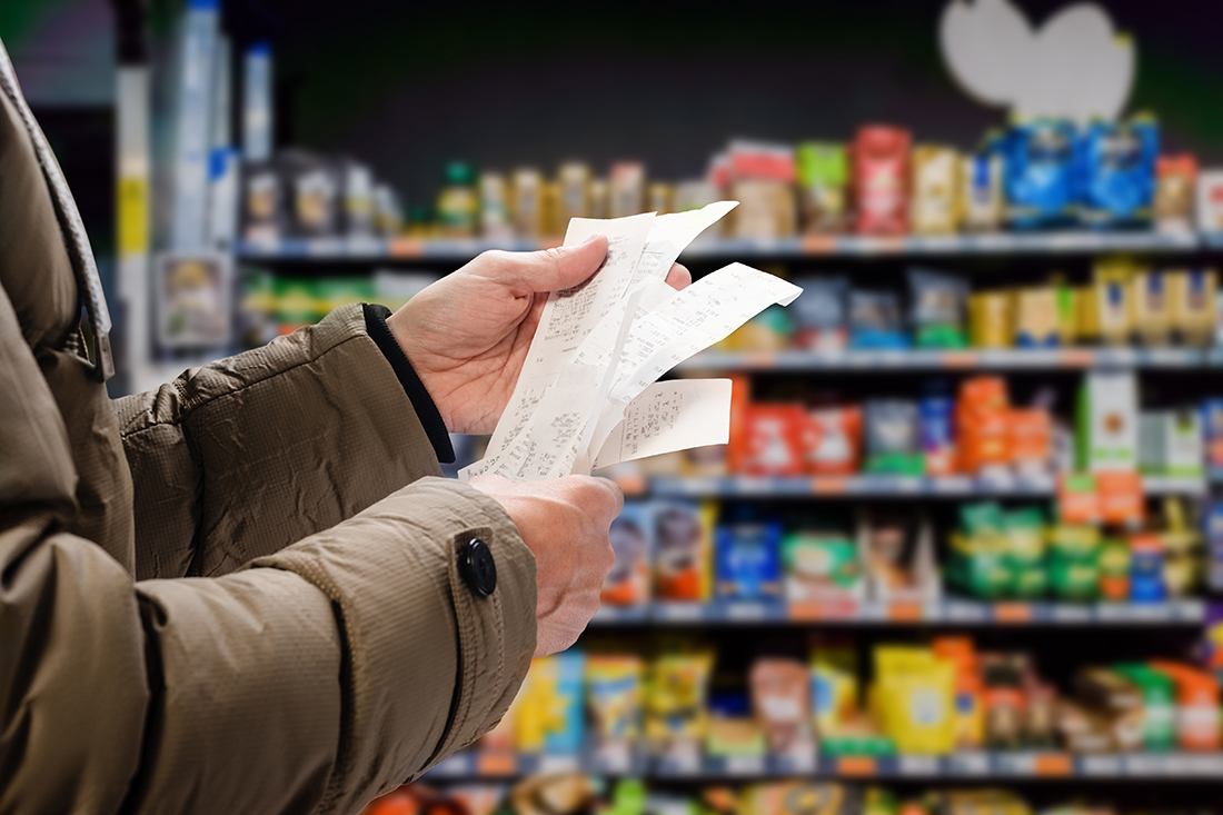 A shopper looks at his grocery receipts. Customer expectations can impact inflation