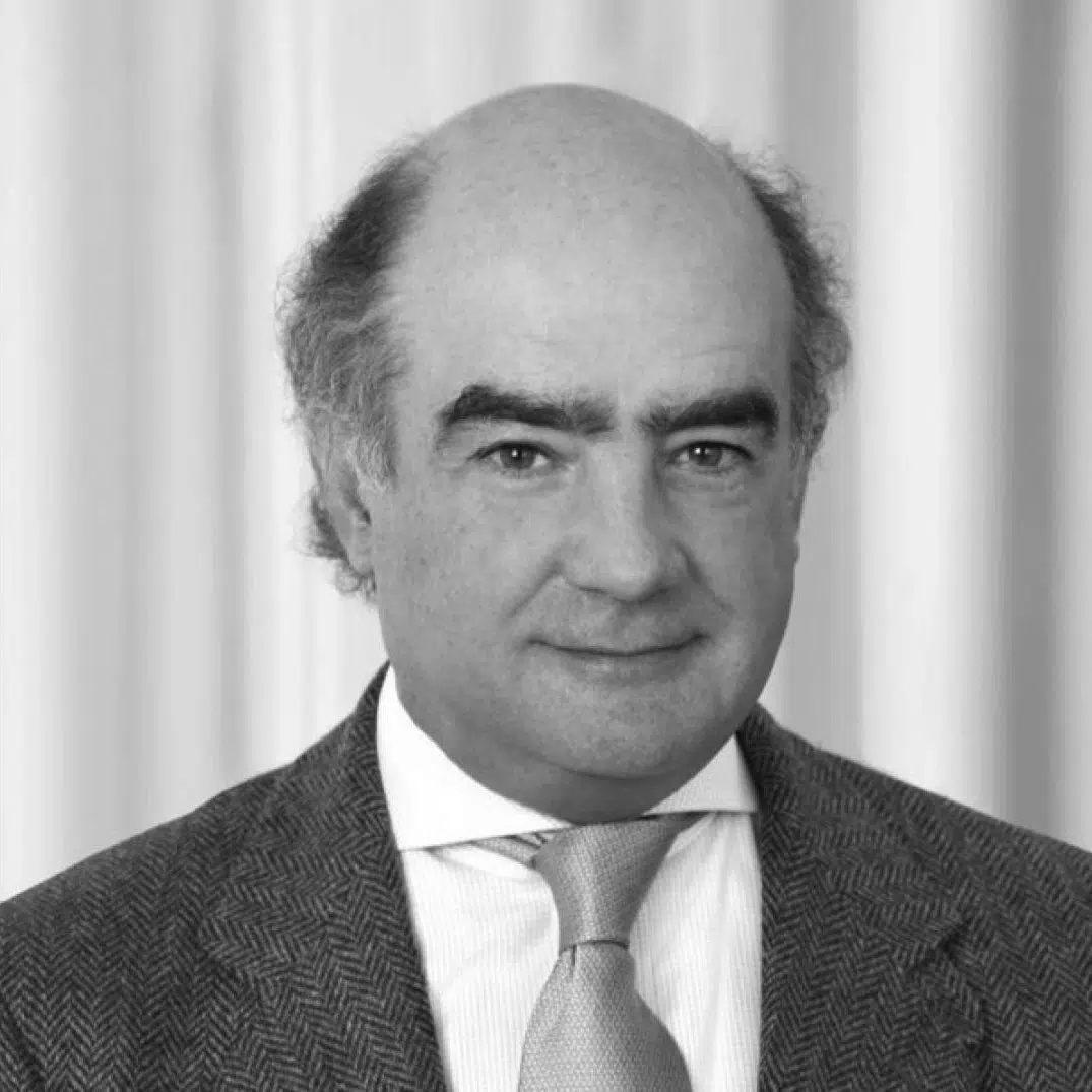 A middle-aged man in a suit and tie, with thinning hair, standing in front of a plain background.